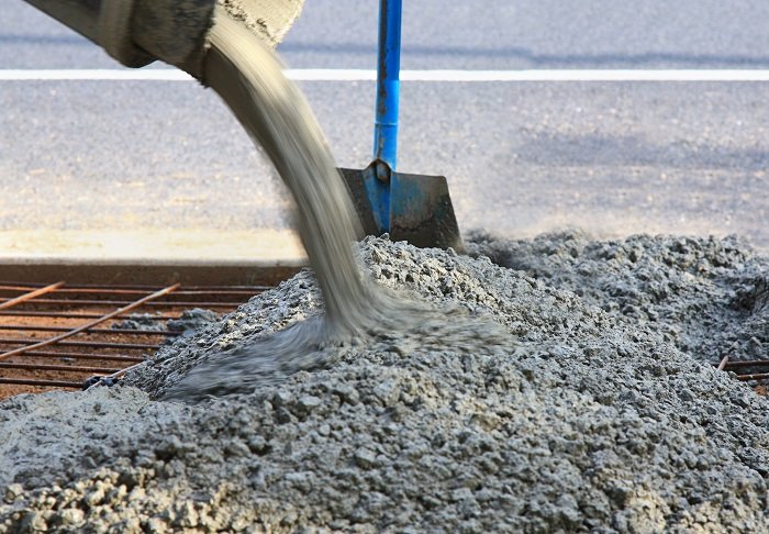 Pouring concrete into a sidewalk form.