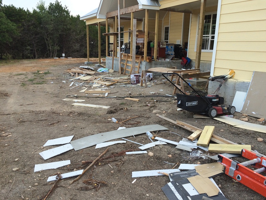 A home under construction with all the materials and trash in the back yard.